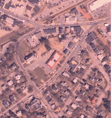 Color photo of some roads and buildings as seen from the sky.