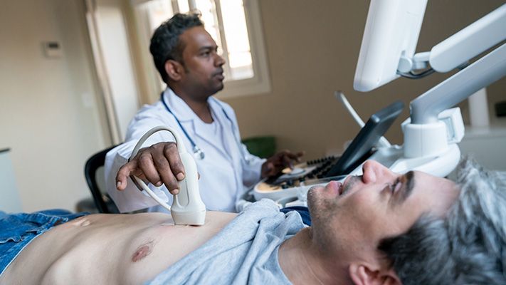 Homme en position allongée, pendant qu'un professionnel de la santé effectue un test de diagnostic.